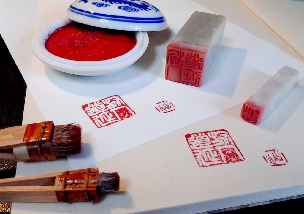 The two hanko, my cleaning brushes and the cinnabar paste next to the final results.